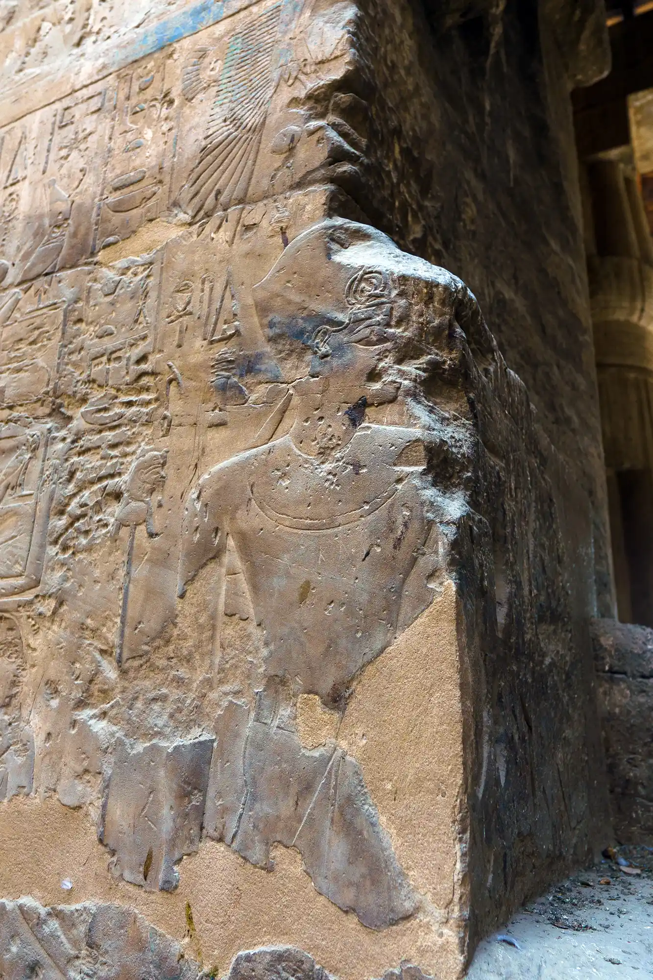 Traces of blue pigment survive on a carved relief figure at Luxor Temple, caught by angled light.