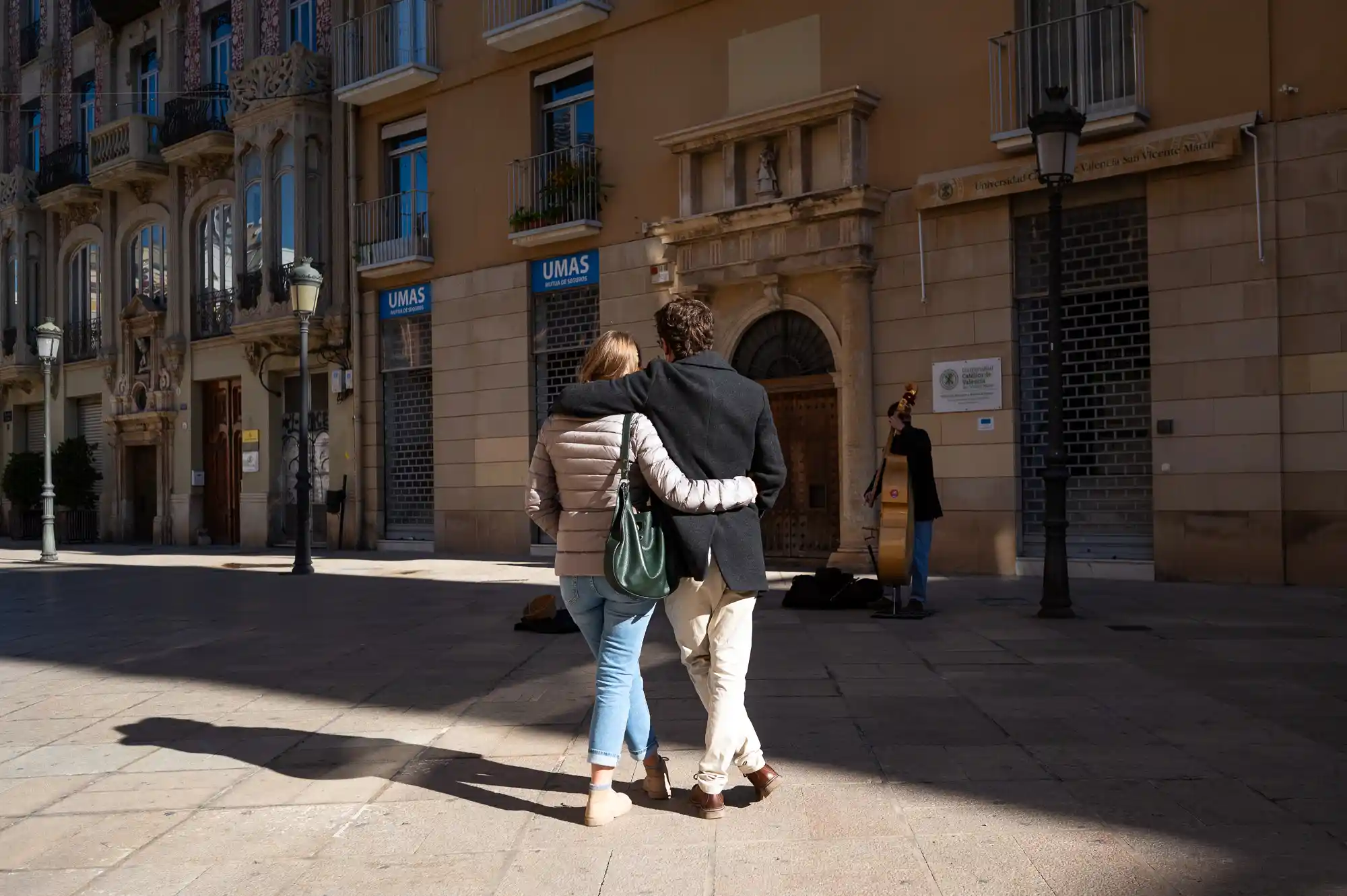 Couple hugging listening to street musician