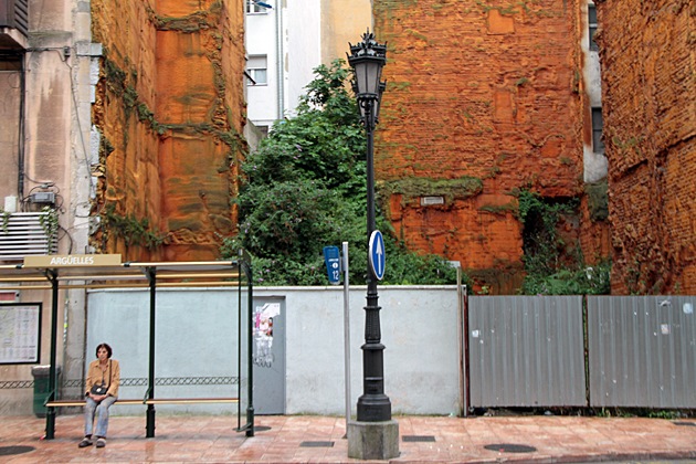 Woman sitting at a bus station in Oviedo, Spain