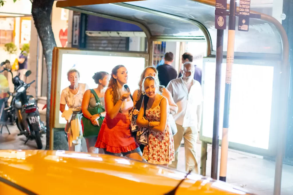 Buenos Aire Night Bus Home girls waiting and smiling at a bus stop